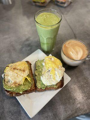 Avocado toast with egg, green drink with pea protein and a cappuccino