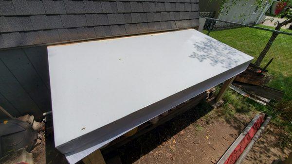 Installing new flat roof membrane on lean-to.