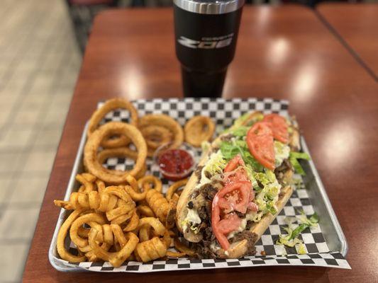 Philly Cheesesteak with mushrooms, onions, American Cheese, lettuce, and mayo with onion rings and curly fries
