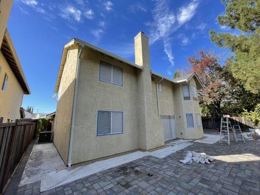 The original house color + windows covered with plastic.