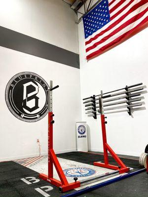 Olympic weightlifting section - men's and women's Olympic barbells, 4 sets of kg bumper plates, jerk blocks, and high/low blocks.