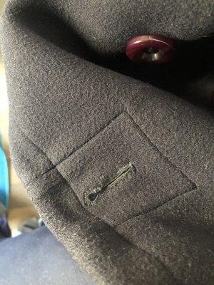 L&S Tailors fire damage fix by extracting wool from inside the hemline of the navy pea coat with a creative outline design that works!