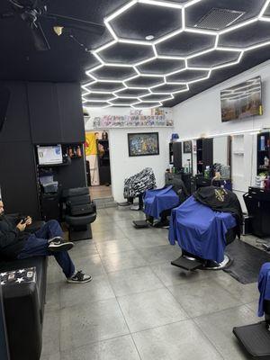 Seating area and additional barbers waiting to make that cut !!! Laser focused