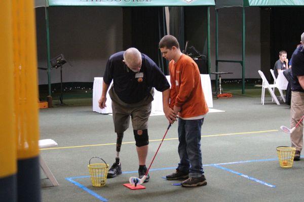 Adaptive Golf Coach Bruce Miller working with a participant on his golf swing!