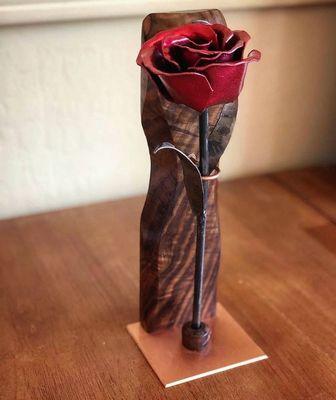 A metallic red rose on a custom walnut and copper stand