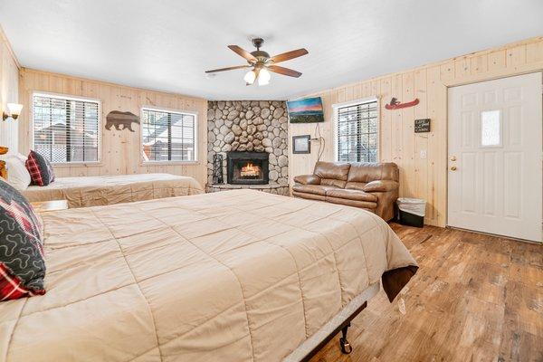 Two queen beds with a wood burning fireplace