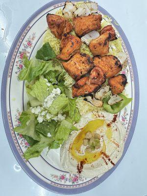 Chicken kabob plate with rice, hummus, and side salad.
