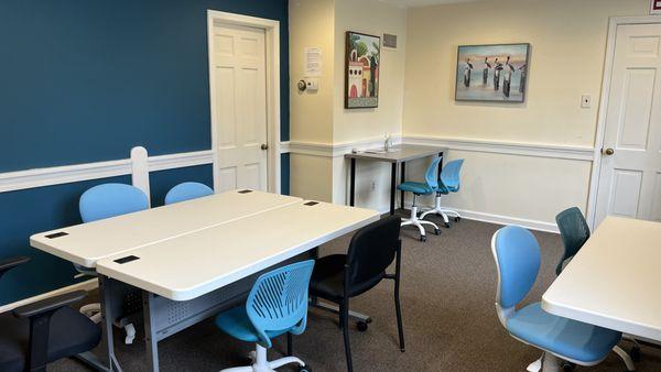 Open therapy room with multiple activity tables at Acclaim Autism
