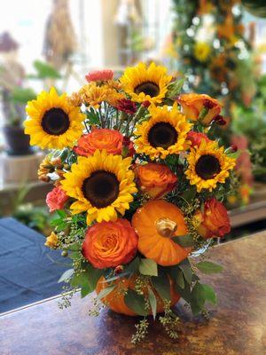 Custom arrangement of sunflowers and roses in a pumpkin