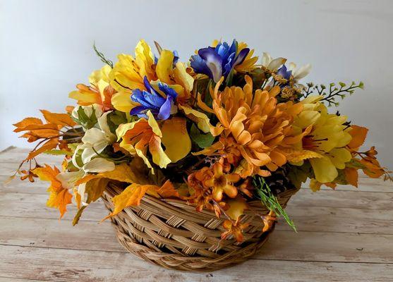 Fall centerpiece with a touch of blue. Mixture of seasonal life-like flowers in woven basket