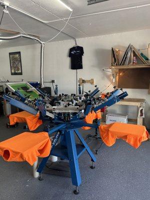 Screen printing press with t shirts loaded onto it ready for custom t shirt printing.