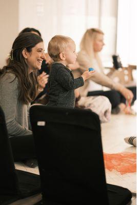 A new Mom smiling as her baby attentively learns