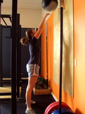 Female demonstrating complete hip extension during a wall ball