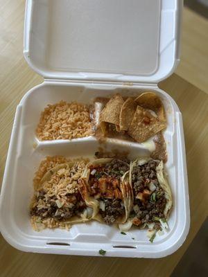 3 asada tacos with everything and a side of red rice and beans with cheese.