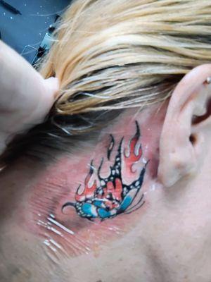 A flaming butterfly with a skull inset