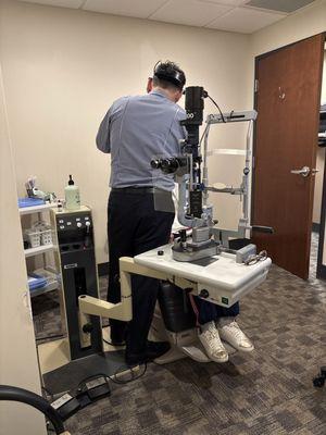 Doctor taking a look at Mom's eyes.