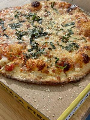 Plain pizza (but definitely not a plain in flavor) with basil