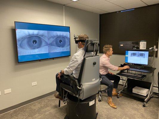 Cory Tickle, audiologist at Colorado Ear Care, performs a balance disorder test using a rotary chair