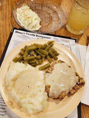 Chicken fried steak and mashed potatoes with gravy over all, green beans, Cole slaw.