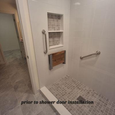 Shower tile: walls, niche and shower base. Flooring tile extending from the bath to the primary closet.