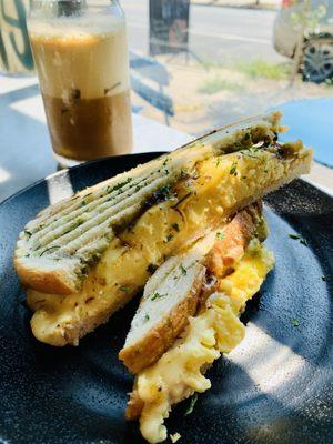 Llama Sunrise Breakfast Panini -- smoked paprika aioli sauce, fluffy eggs, bacon jam, creamy guacamole, mozzarella cheese
