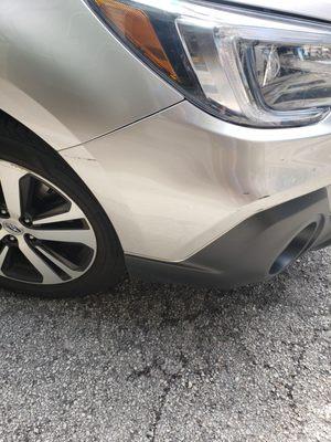 Damage to front bumper, scrapped against a wall or another vehicle.