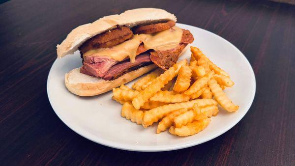 Brisket Sandwich topped with gouda cheese, onion rings on a hoagie bun.