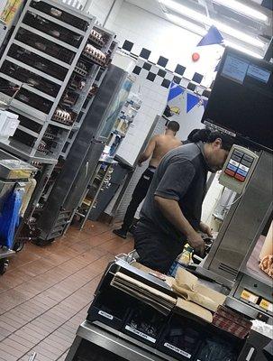 Employee, shirtless, cleaning himself with wet rags.
