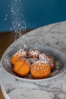 Beignets, a fried donut dusted in powder sugar