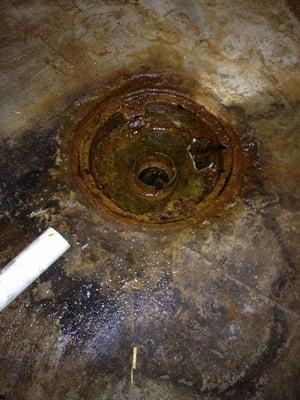 Utility floor drain for HVAC in basement of home (1957).