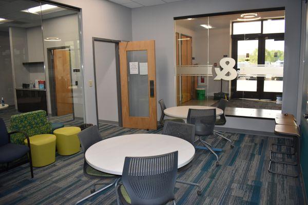 This cozy lounge area provides round tables and colorful soft seating, perfect for student collaboration or relaxing between classes.