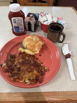 Breakfast Sandwich Sausage with scrambled eggs and American cheese on a croissant or toast. Extra crispy hash browns and coffee