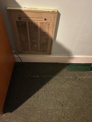 Heater, filthy and badly painted, with green duct tape over a vent