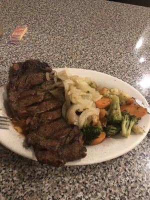 Ribeye cooked perfectly to medium rare. Butter grilled onions and grilled mixed vegetables.