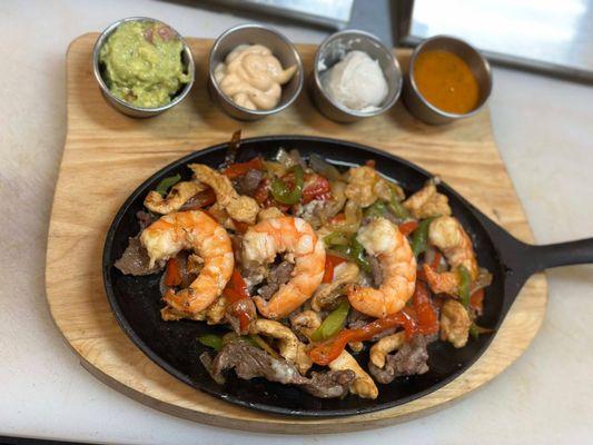 Triple meat Fajitas! Shrimp, Steak, and Chicken all sizzling with seasoned veggies.