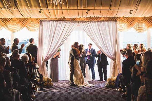 White linen canopy used for indoor wedding ceremony