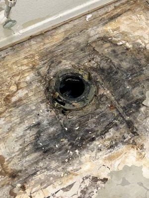 Under the toilet, they just put the tile back on with a new seal