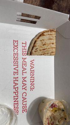 Eyelash on pita bread. Greasy hummus with unidentified oil. Ironic message in take out box.