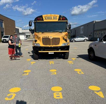 A mirror station with painted circles and A-P letters around the bus to help drivers adjust mirrors for full visibility of danger zones