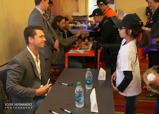 Junior Giants Community Fund's Play Ball Luncheon 2015 | Buster Posey Signing an Autograph for a Fan.