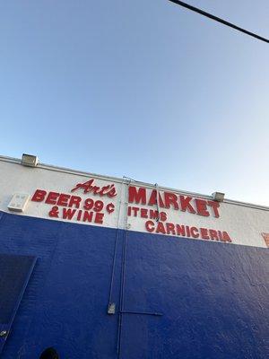 The name of the store, offering wine, beer, and carniceria.