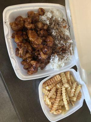 Orange chicken, white rice with soy sauce added and french fries