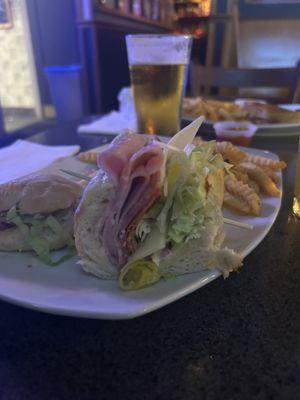 Grinder sandwich, and turkey bacon, Swiss in the background.