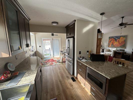 Smaller island, fridge in former pantry space, opened area all the way to the backyard. More light!