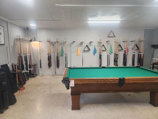 Billiard cues, pool table, towels, racks