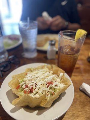 Beef taco salad in a shell bowl.