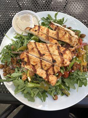 Daily special - harissa grilled chicken over roasted asparagus, feta, roasted red pepper, arugula, and onions with lemon tahini dressing.