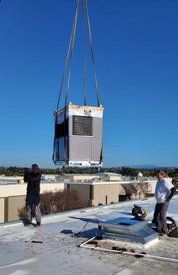 Our installers guiding a crane to set package unit at one of our commercial client's warehouse.