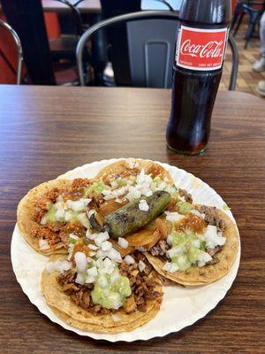 Four tacos (asada, carnitas, pollo, chorizo) and a Coke.