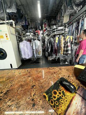 The inside of Valet Dry Cleaning, standing at the front desk.